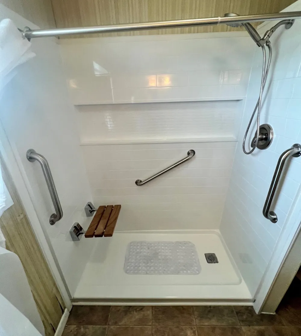 Accessible walk-in shower with grab bars and fold-down seat